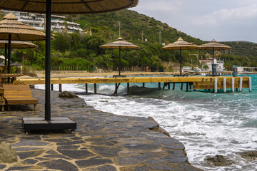 Empty sunbeds and parasols on morning, by the sea. Sand beach in luxury hotel resort near sea. Beautiful morning seascape.