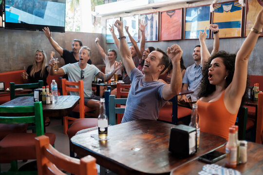 Excited fans cheering in a sports bar