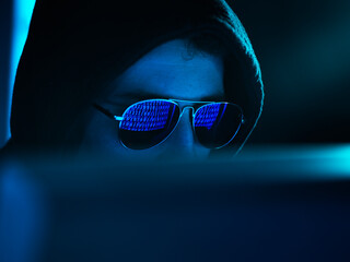 Cyber Crime, reflection in spectacles of virus hacking a computer, close up of face