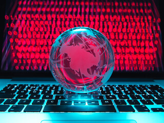 Globe illustrating the Americas on a laptop computer with screen been infected by a cyber attack