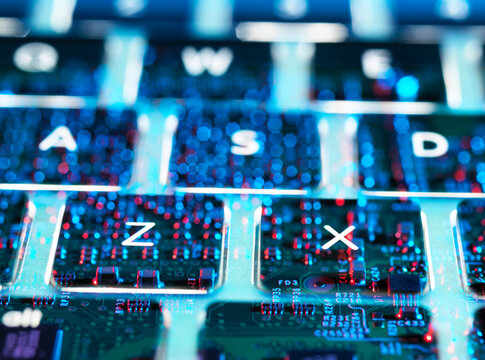 Double exposure of a laptop computer showing electronic components under the keyboard
