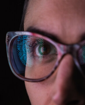 Woman with a reflection of a finger print on her glasses to represent identity and access