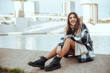Young brunette woman wearing black and white coat and scarf in the city