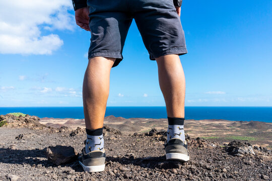 Spain, Canaray Islands, Fuerteventura, legs of a man standing at the coast