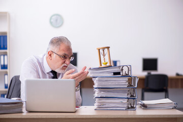 Old male employee in time management concept