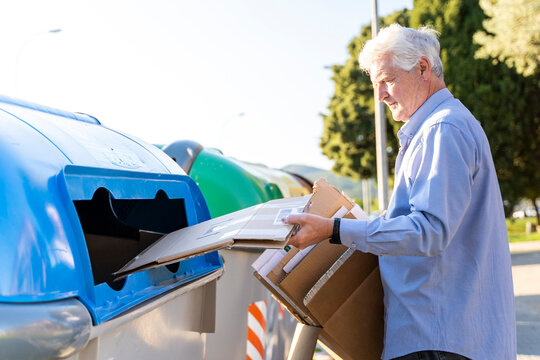 Senior man recycling cardboard in paper bank