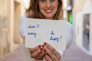 Portrait of smiling woman, holding notebook: Don't worry be happy!