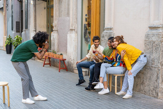 Man taking a picture of friends having a drink in the city