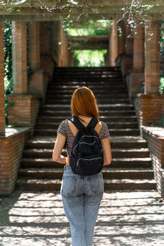 Back view of woman with black backpack