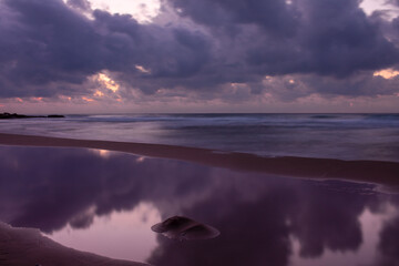 Amanecer rosado sobre el mar en un cielo nublado