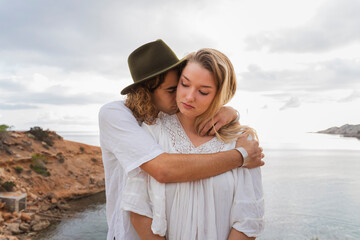 Young couple in love standing in front of the sea, Ibiza, Balearic Islands, Spain