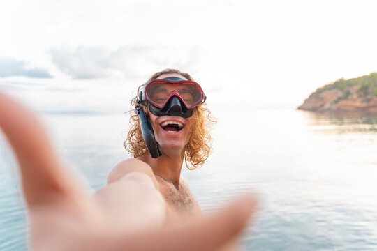 Young man with snorkel making a face on the beach