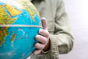 Hand with protective glove, touching globe