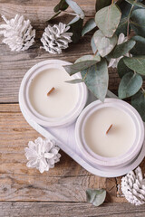 Handmade scented soy wax candles and Christmas decorations. Wooden background. Top view