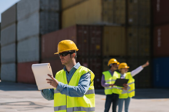 Workers in front of cargo containers on industrial site
