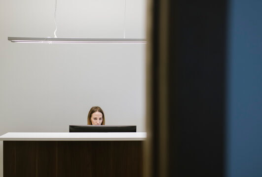 Young woman working at the reception desk in office