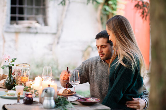 Romantic couple having a candlelight meal at garden table