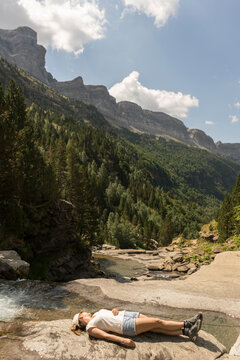 Woman lying on a rock in the mountains, Ordesa national park, Aragon, Spain
