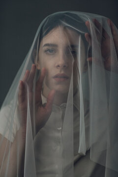 Melancholic woman under a veil