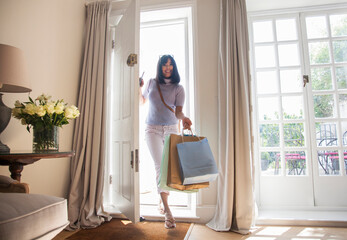 Woman with shopping bags, coming through front door