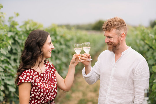 Couple toasting with white wine in the vineyards