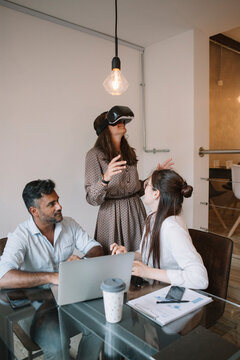 Colleagues working in office testing VR simulator
