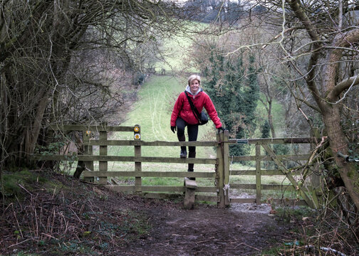 UK, Gloucester, Chipping Sodbury, Cotswold Way, woman on a hiking trip crossing pasture fence