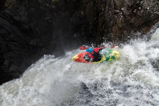 Man kayaking on waterfall on river