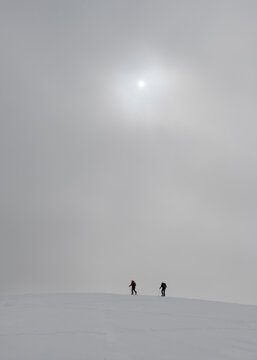 Georgia, Caucasus, Gudauri, people on a ski tour under hazy sky