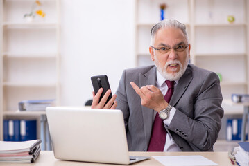 Old male employee working in the office