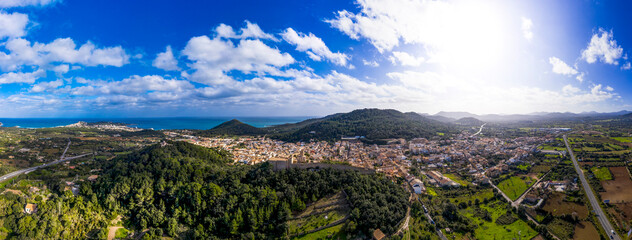 Aerial view of village by Mediterranean Sea against blue sky on sunny day