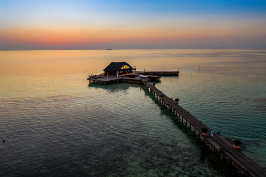 Maldives, Olhuveli island, Pier and building on South Male Atoll lagoon at sunset