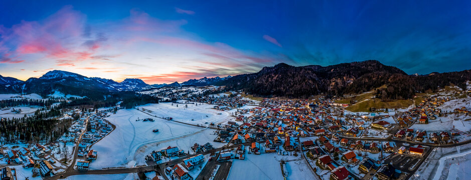 Germany, Bavaria, Reit im Winkl, Helicopter view of snow-covered mountain village at dawn