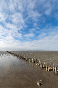 Denmark, Romo, Clouds over old groyne stretching along mud flat