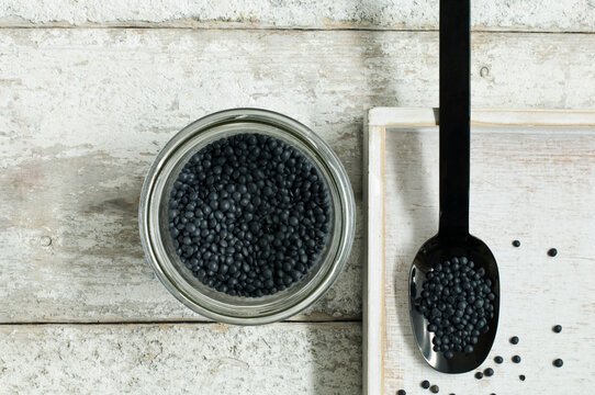 Jar Of Beluga Lentils On Wooden Table Seen From Above