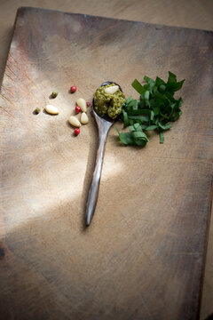 Ramson pesto on spoon and ingredients on wood