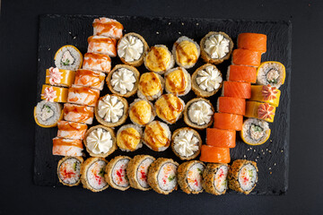 Assortment of fresh prepared sushi on black background.