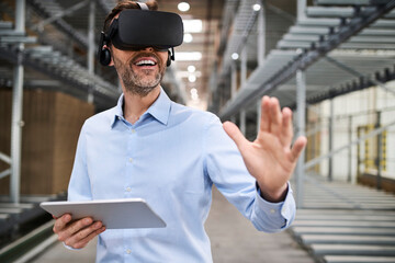 Businessman with tablet wearing VR glasses in factory