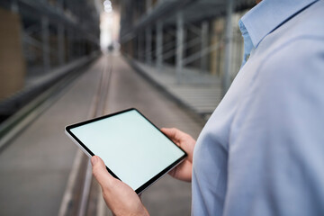 Close-up of businessman holding tablet in factory
