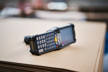 Barcode scanner lying on cardbox in factory