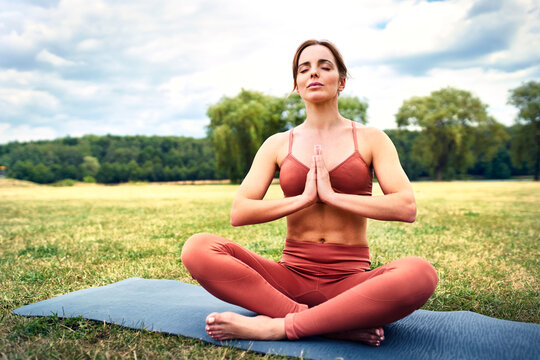 Woman practicing yoga in park meditating