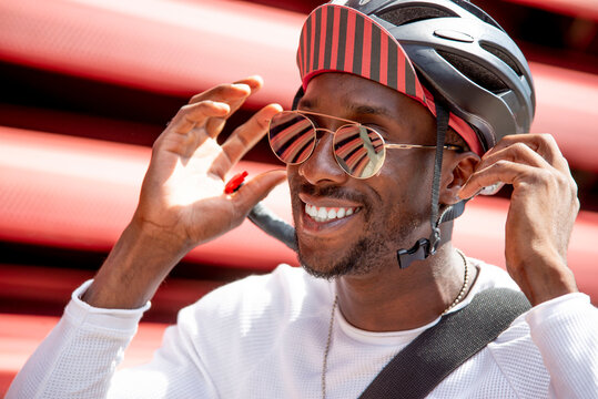 Smiling young man putting on his cycling helmet