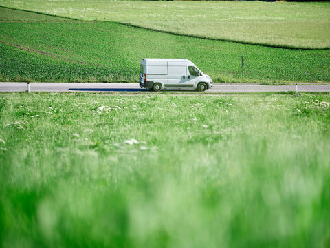 Delivery Van moving on highway along green field