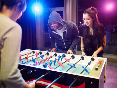 Happy friends playing foosball
