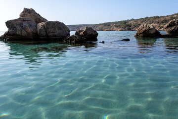 Crystal clear blue water of Mediterranean sea  and yellow rocks in on Konnos beach near Protaras, Cyprus