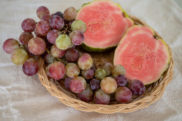 Fresh ripe pink guava tropical fruit and sweet table grapes ready to eat