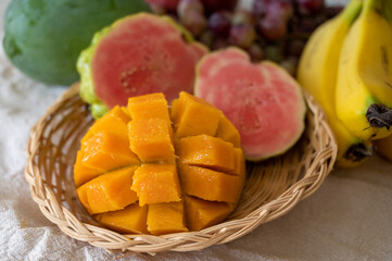 Exotic fruits of Cyprus, fresh yellow juicy mango, ripe pink guava, bananas and sweet table grapes