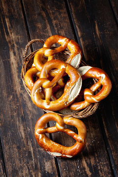 Five pretzels in basket on wood