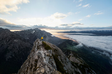 Austria, Tyrol, Gnadenwald, Hundskopf, male climber standing on rock in the morning light