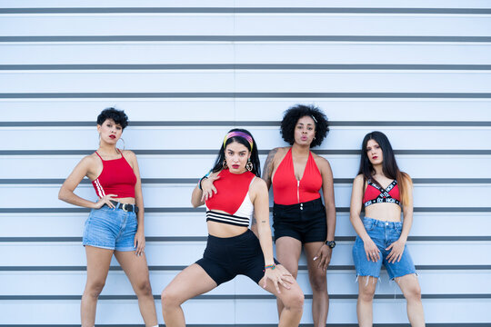 Four young sexy dancing on a strett in front of a wall